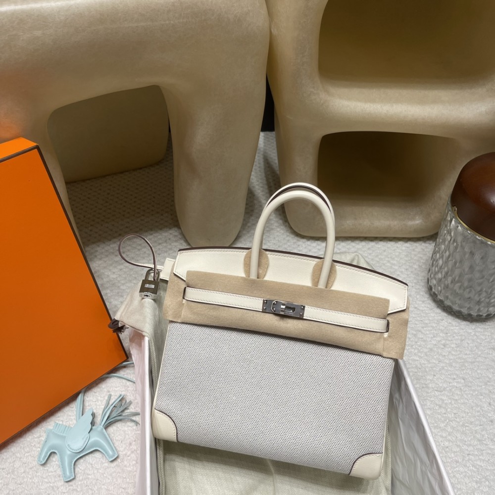 Hermès Birkin 25 (Triomphe H Canvas & Swift Leather) – Color: I2/Nata (with Silver Hardware) – A soft cream-white hue – This model is characterized by a combination of high-quality Swift leather and lightweight canvas. The natural cream-white color create
